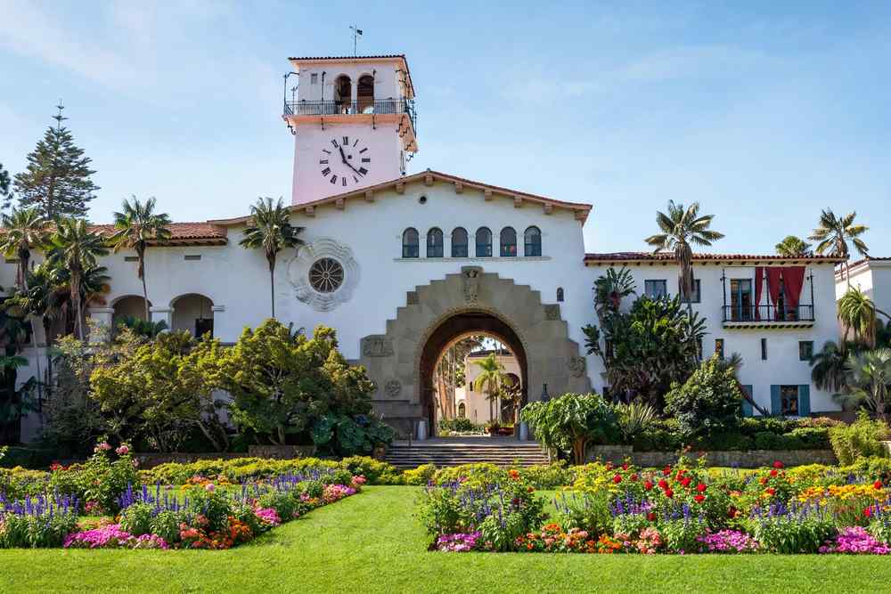 Red-tile rooftops and palm trees in downtown Santa Barbara with the Santa Ynez Mountains behind